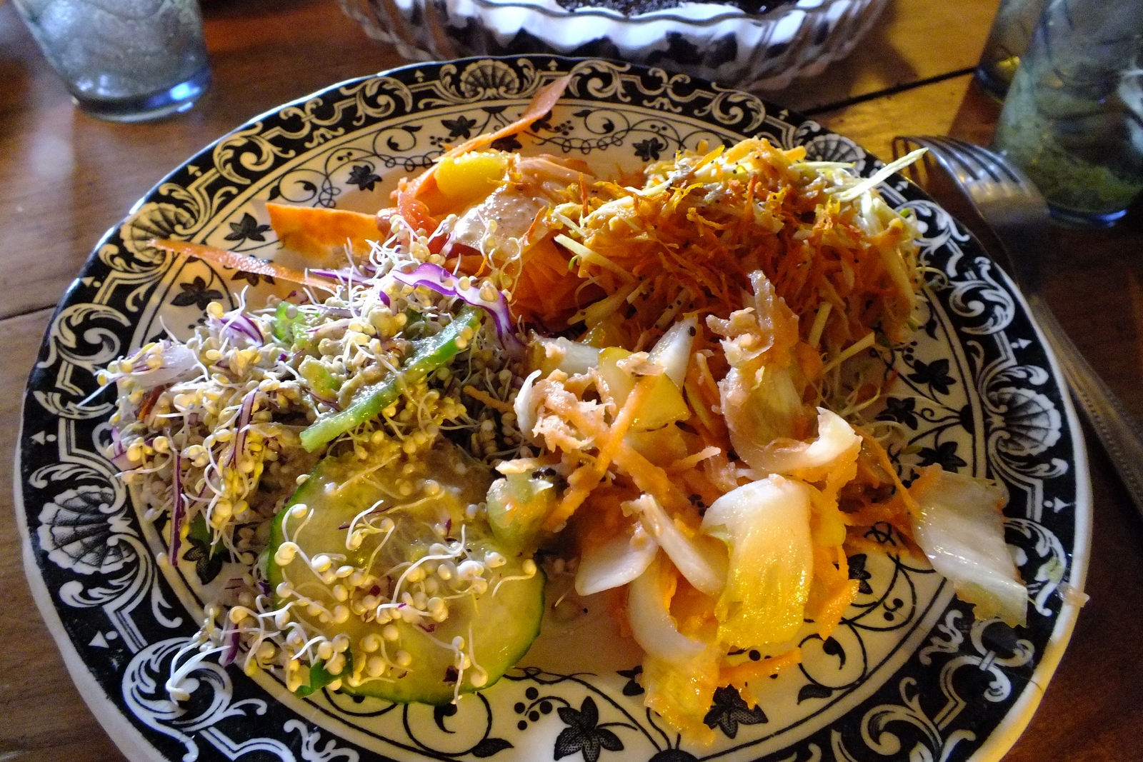 Photo d'une belle assiette sur table en bois brun foncé : légumes finement coupés et mélangés soigneusement.